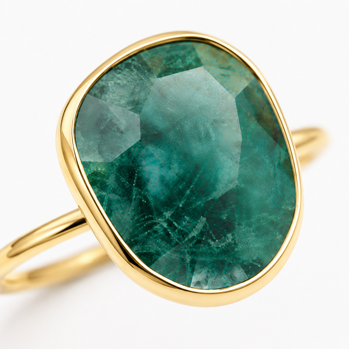 Close-up of the faceted emerald green center and gold-plated setting.