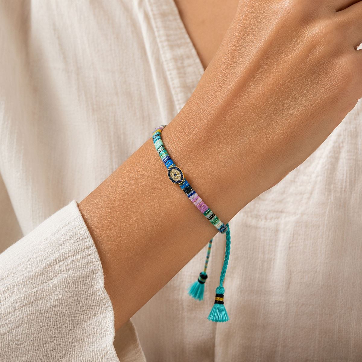 Colorful evil eye bracelet with woven threads and tassel ties shown from above.