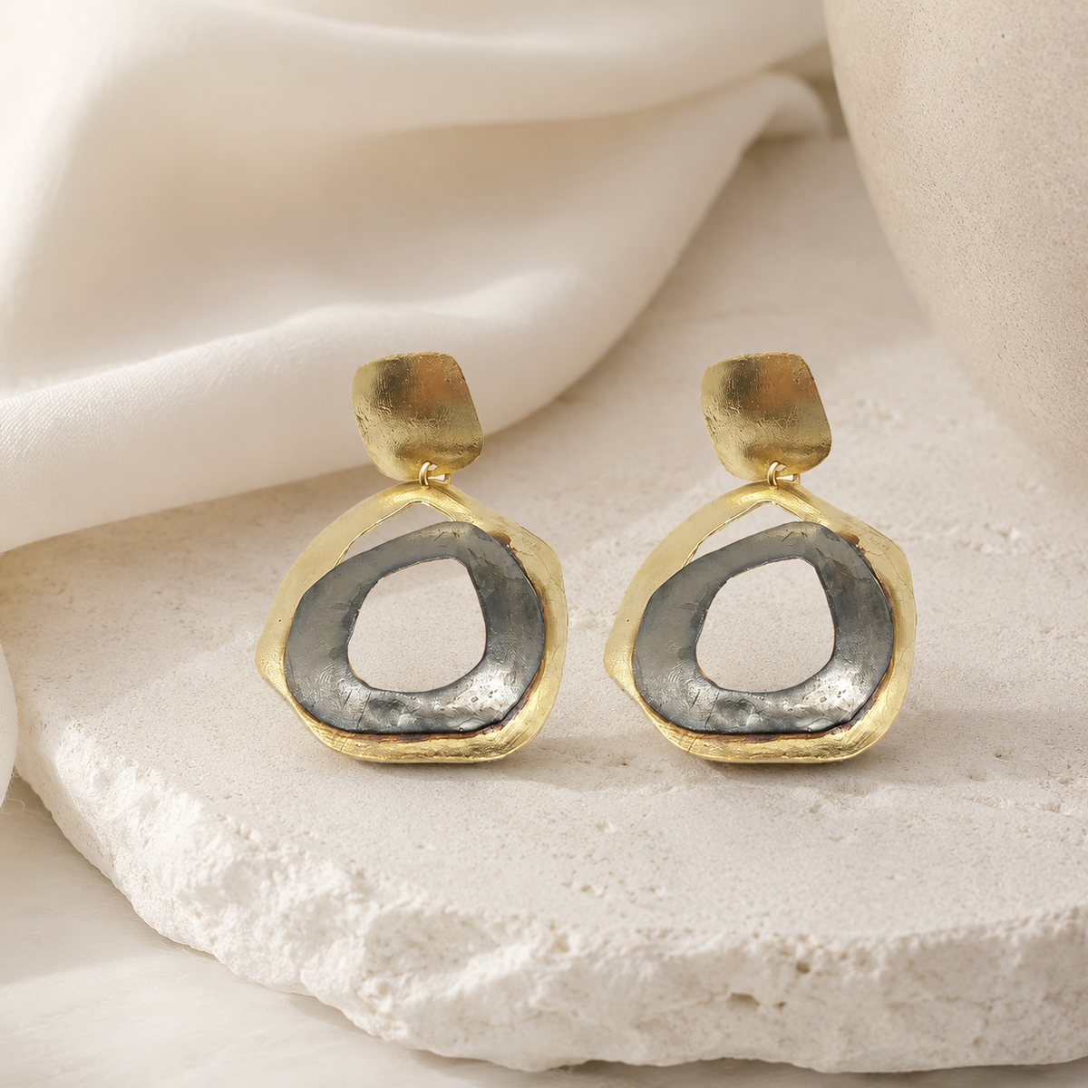 Abstract two-tone circle drop earrings with a gold-tone frame.