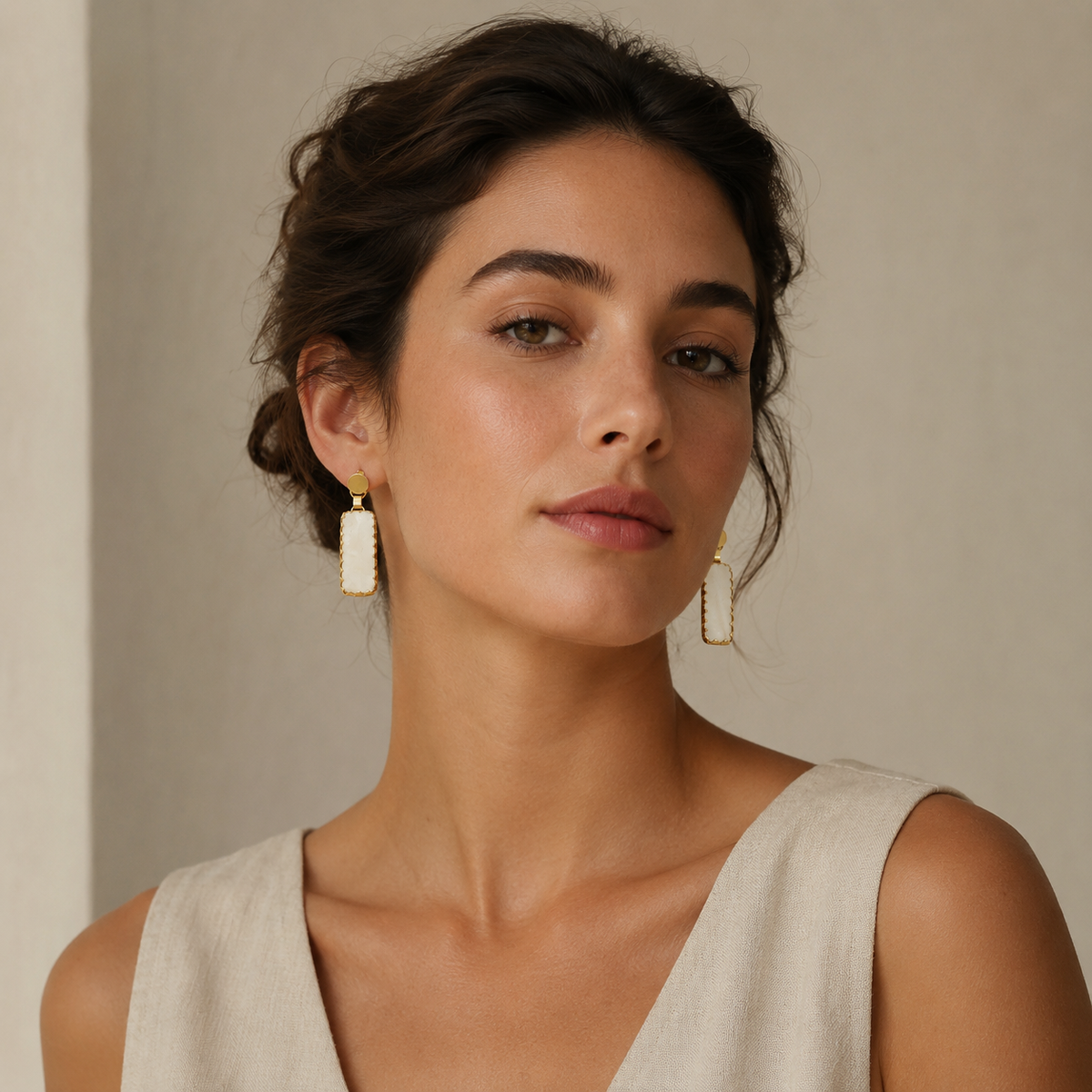 Gold-plated earrings with green agate and baroque pearl-inspired drops on a white background.