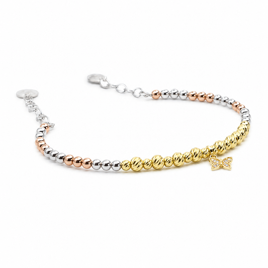Bracelet with mixed metallic beads and a butterfly charm on a white background.