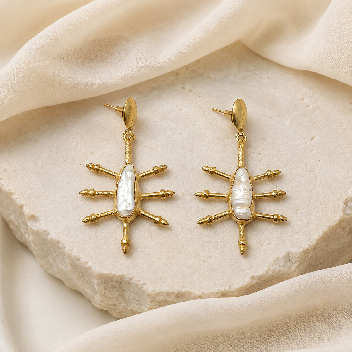 Gold-plated drop earrings with a blue sapphire look styled in a graceful, sculptural shape.