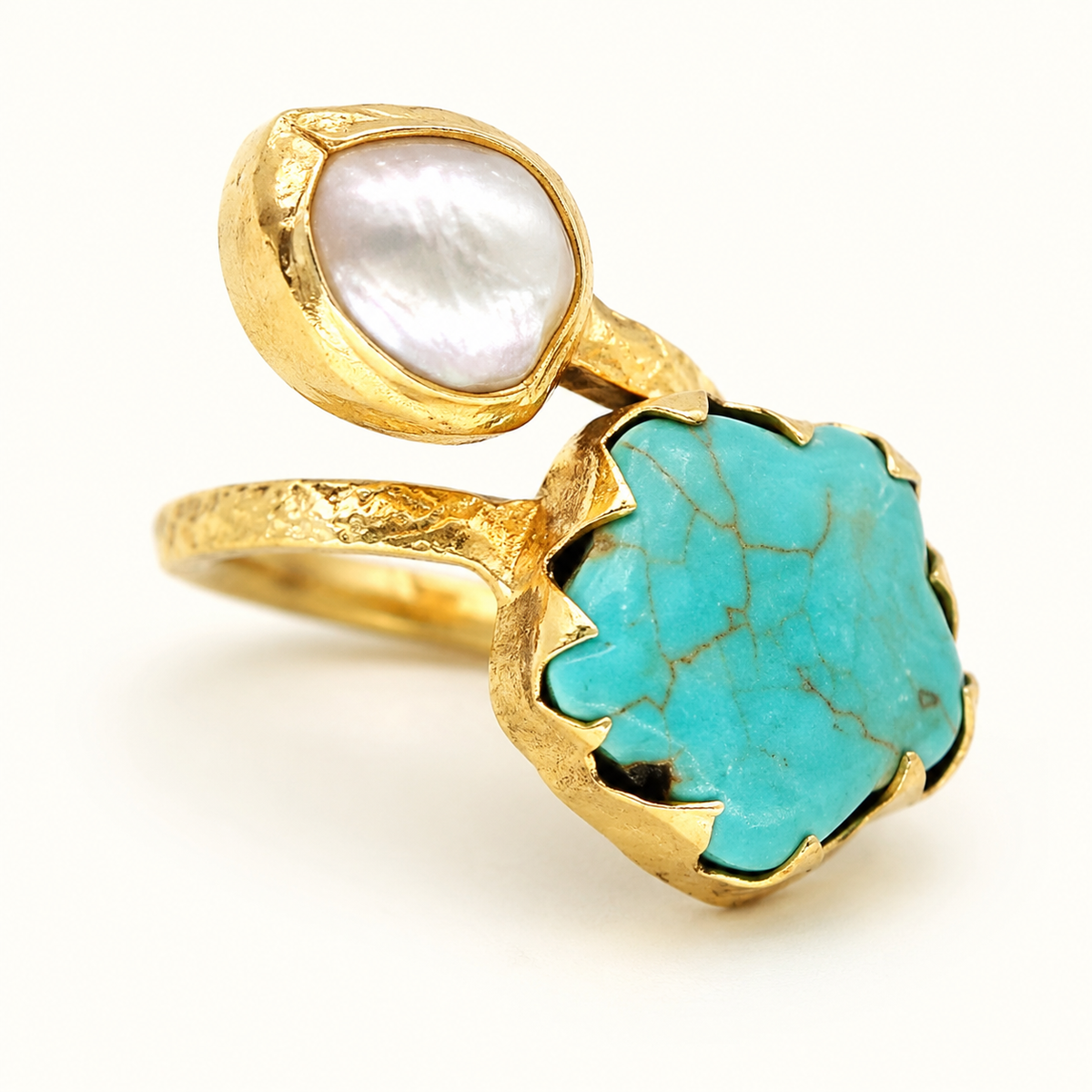 Close view of a gold ring with turquoise and pearl-like stones.