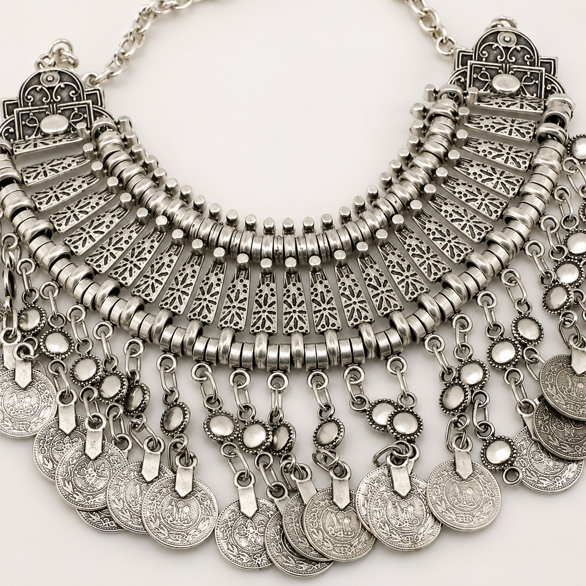 Close view of the necklace’s textured metalwork and layered coin fringe.