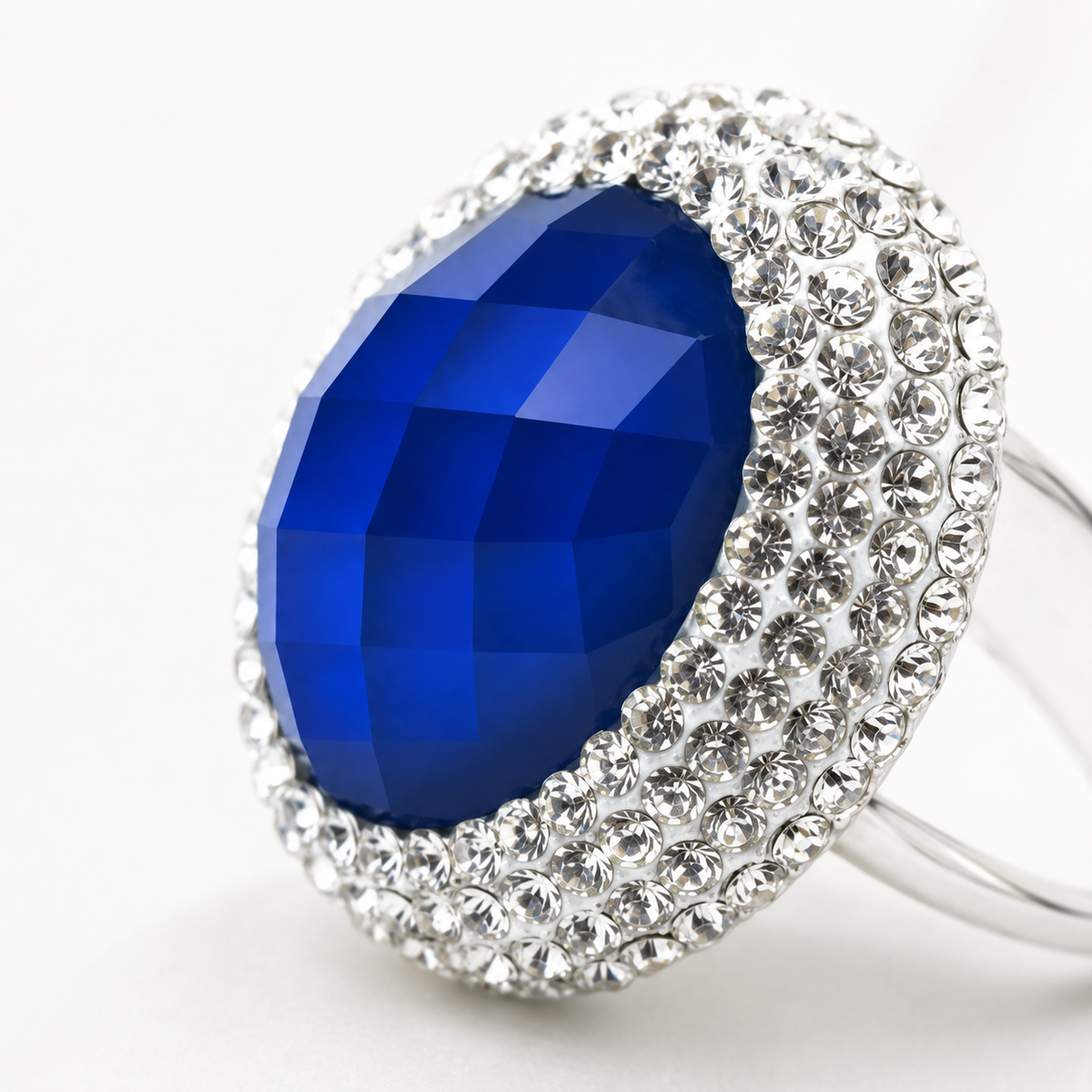 Close view of the faceted blue center stone and clear surrounding accents.