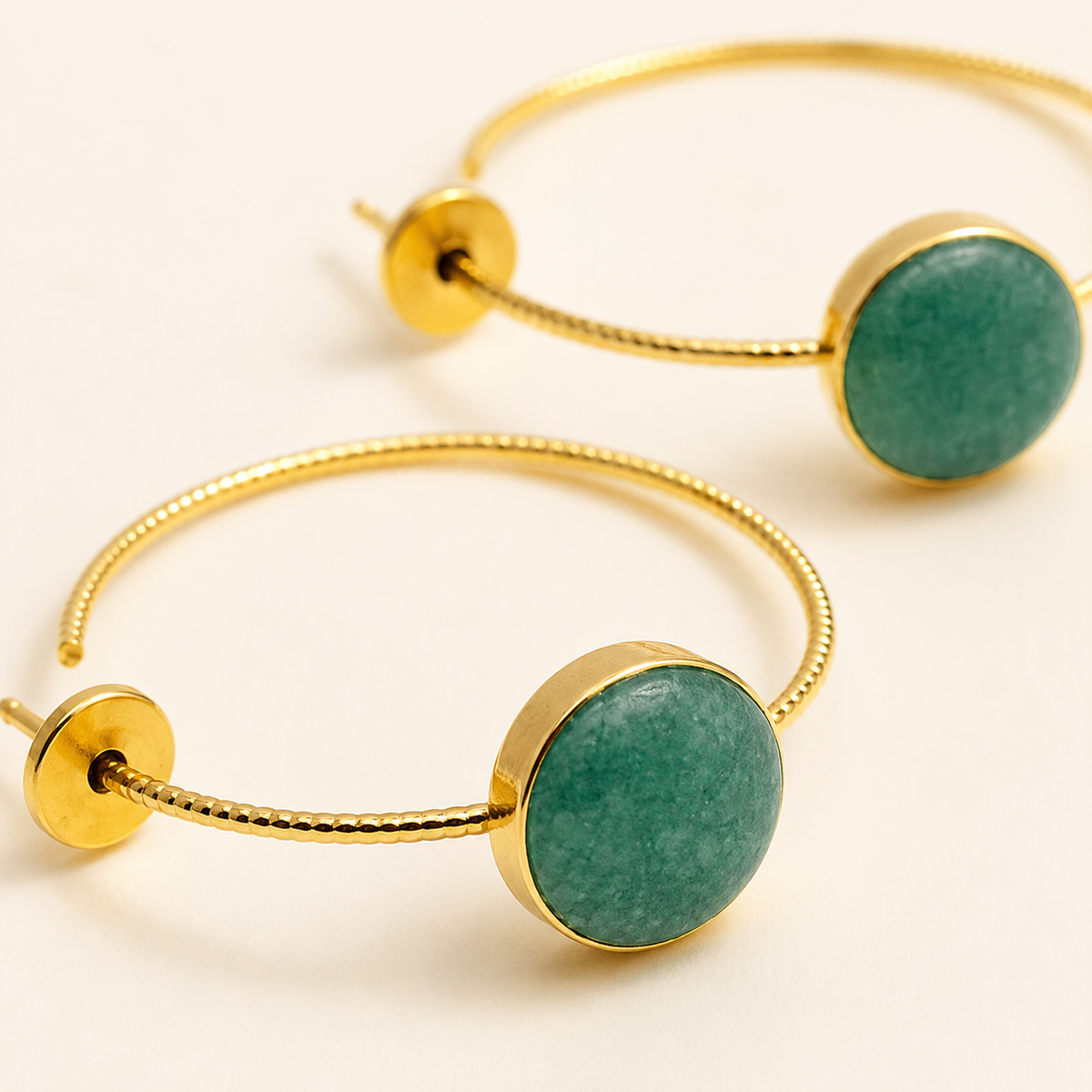 Close view of the green aventurine stone and polished gold-plated setting.