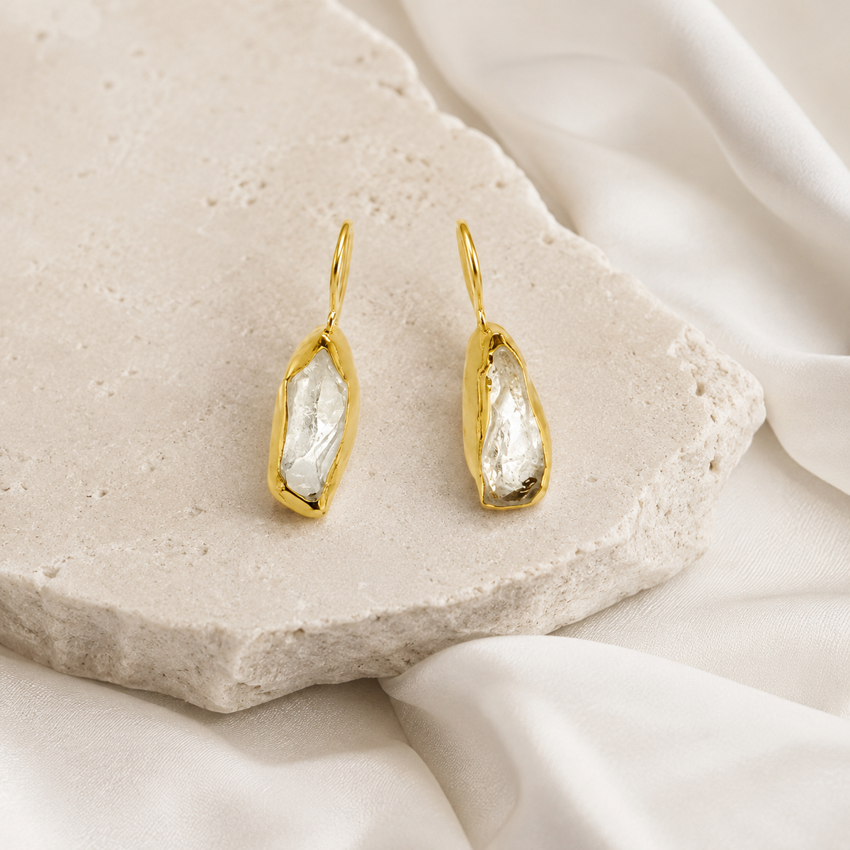 Clear quartz drop earrings with a polished gold-plated finish.