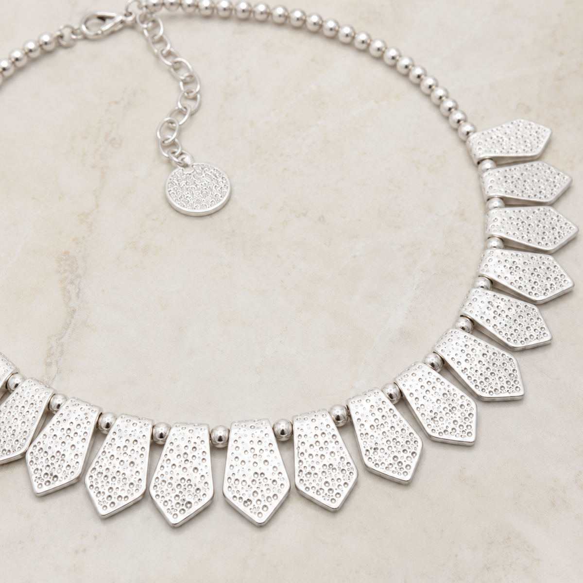 Close view of the textured silver-tone pendant details.