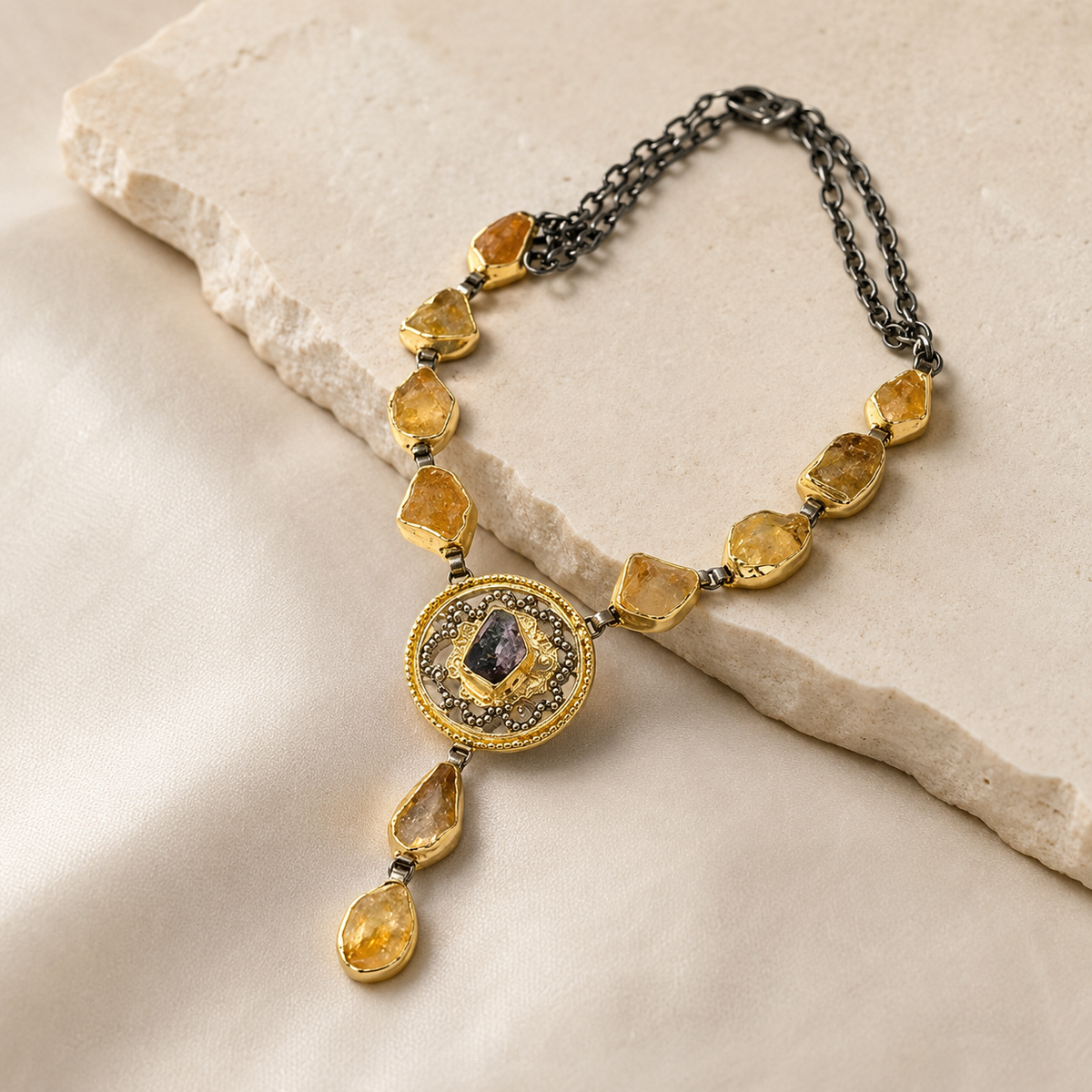 Angled view of the citrine medallion drop necklace showing the pendant and stone links.