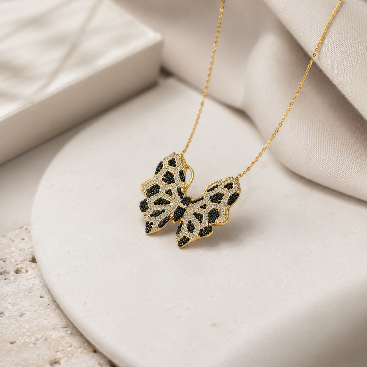 Angled view of a butterfly pendant necklace with black CZ detailing.