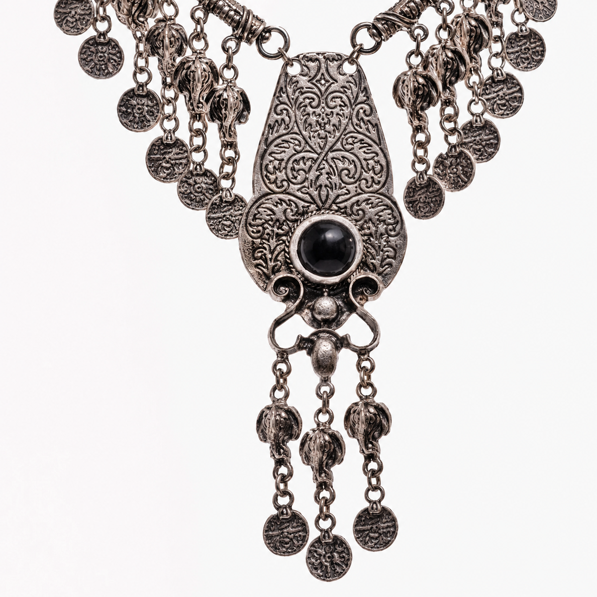 Close view of the ornate pendant and fringe coin accents on the necklace.