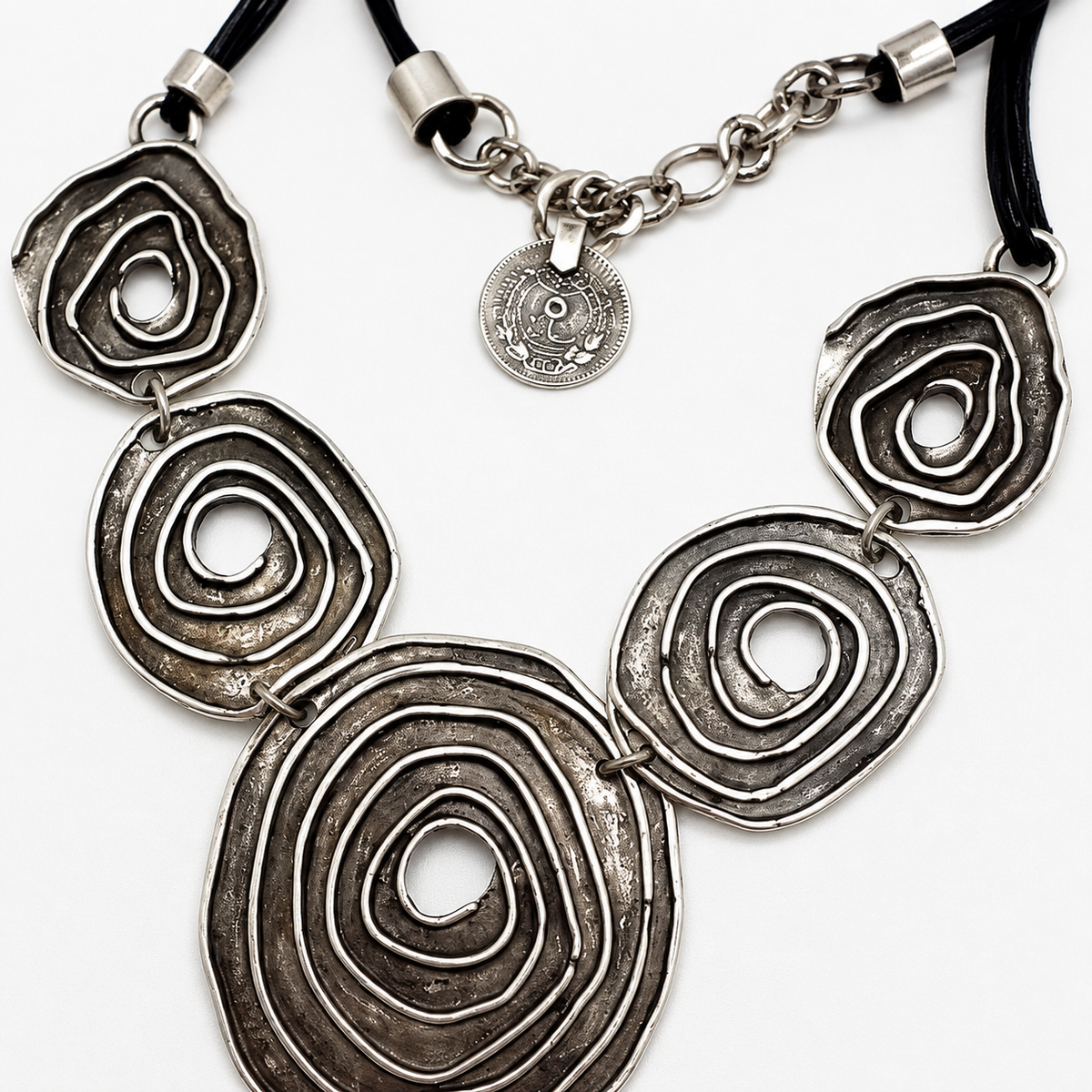 Close view of the spiral circle pendant details and metallic finish.