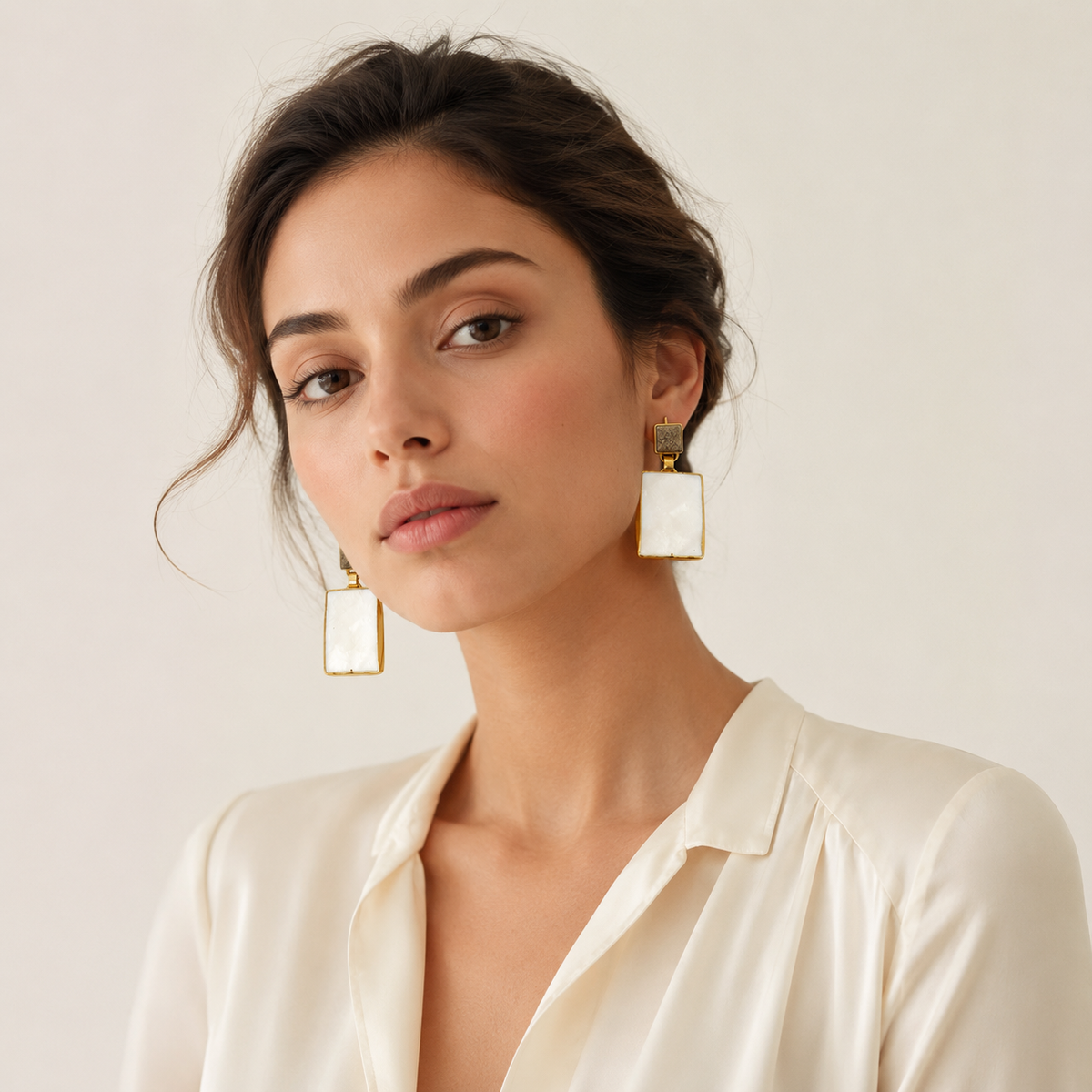 Gold-tone heart earrings with black onyx stones shown front view.