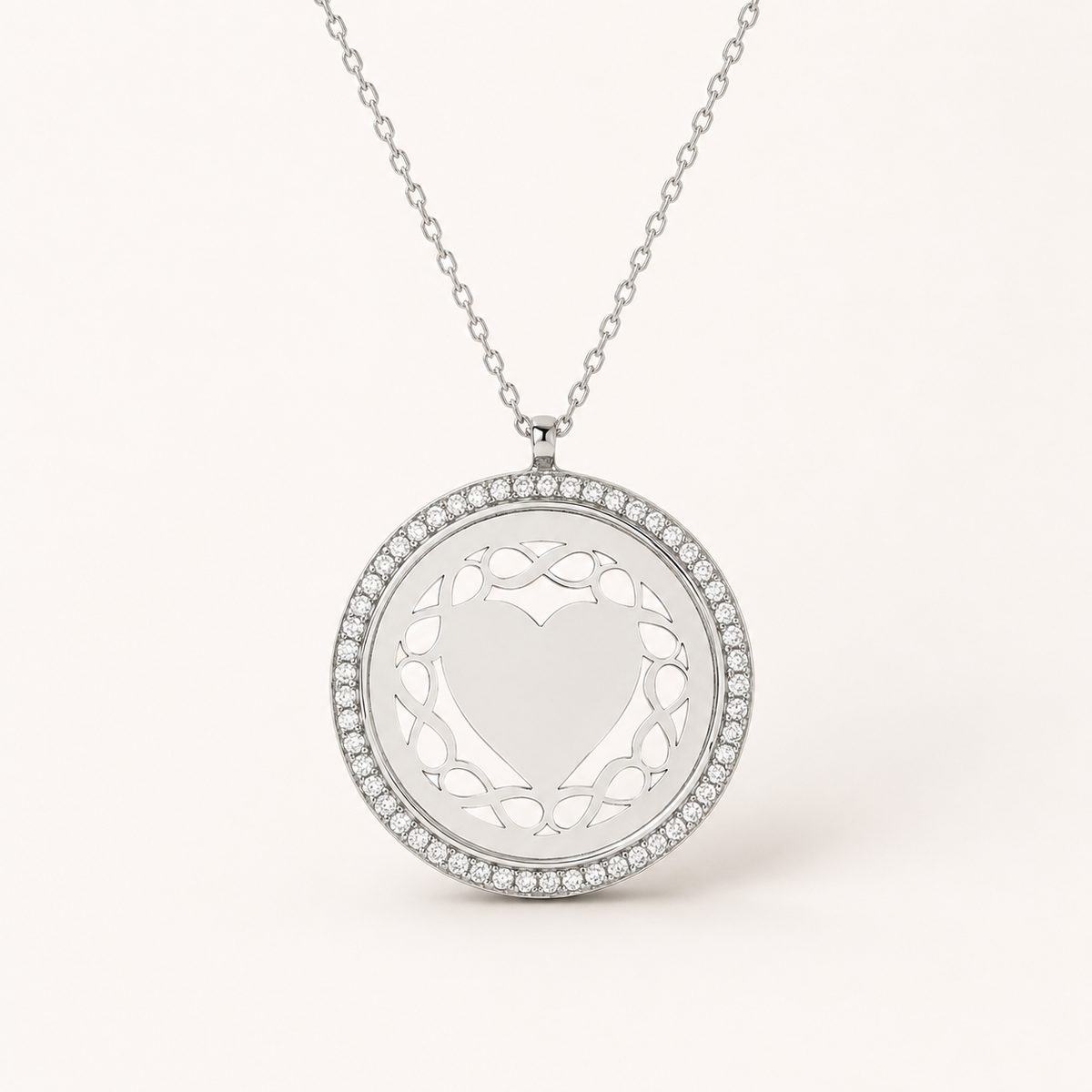 Round silver-tone necklace with a diamond-like frame and open heart-inspired center.
