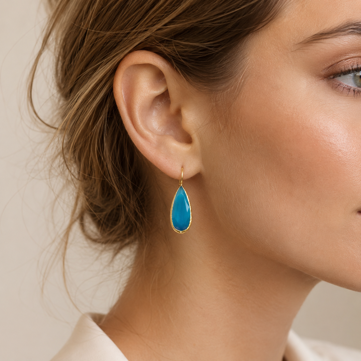 Ocean blue teardrop earrings shown front view with a polished gold finish.