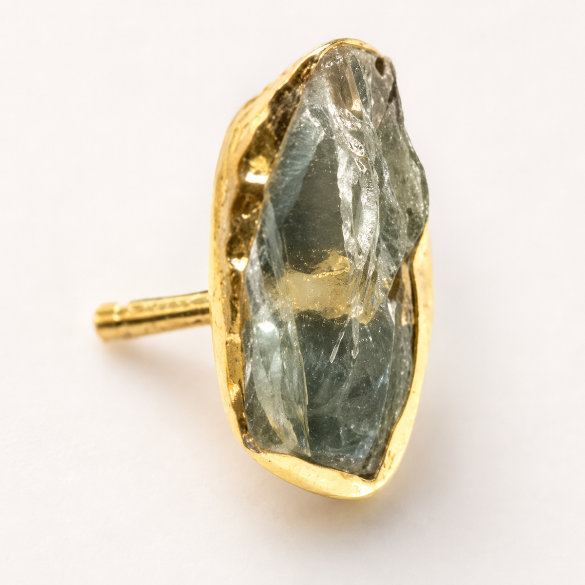 Close view of the raw green amethyst stone and gold-plated setting.