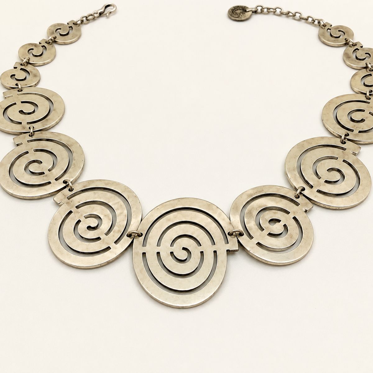 Close view of the spiral circle pendant links and gold-tone finish.