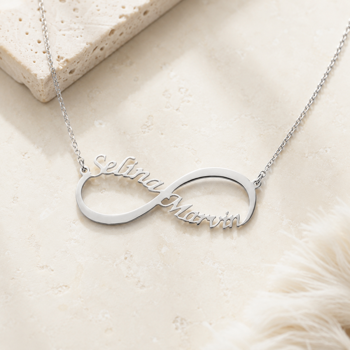 Angle view of a silver-tone personalized infinity name necklace.