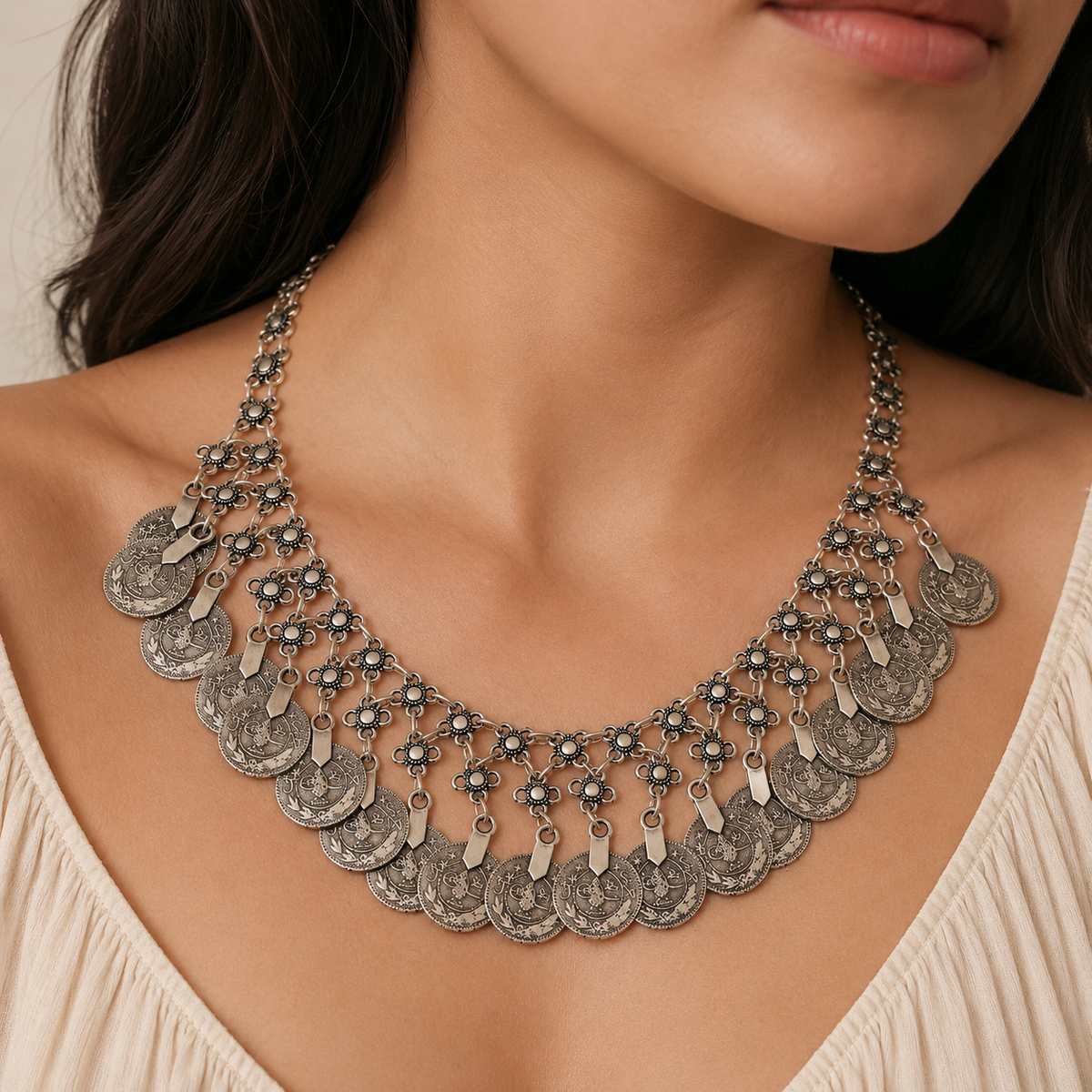 Silver-tone floral coin fringe bib necklace shown on a white background.