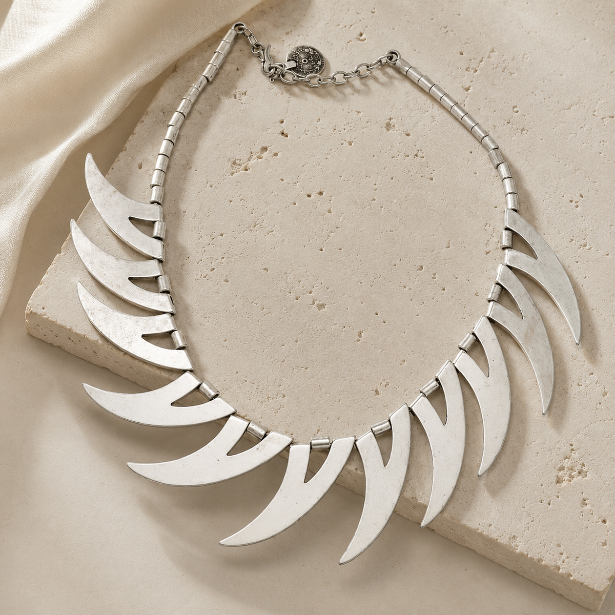Silver-tone statement necklace with curved crescent shapes.