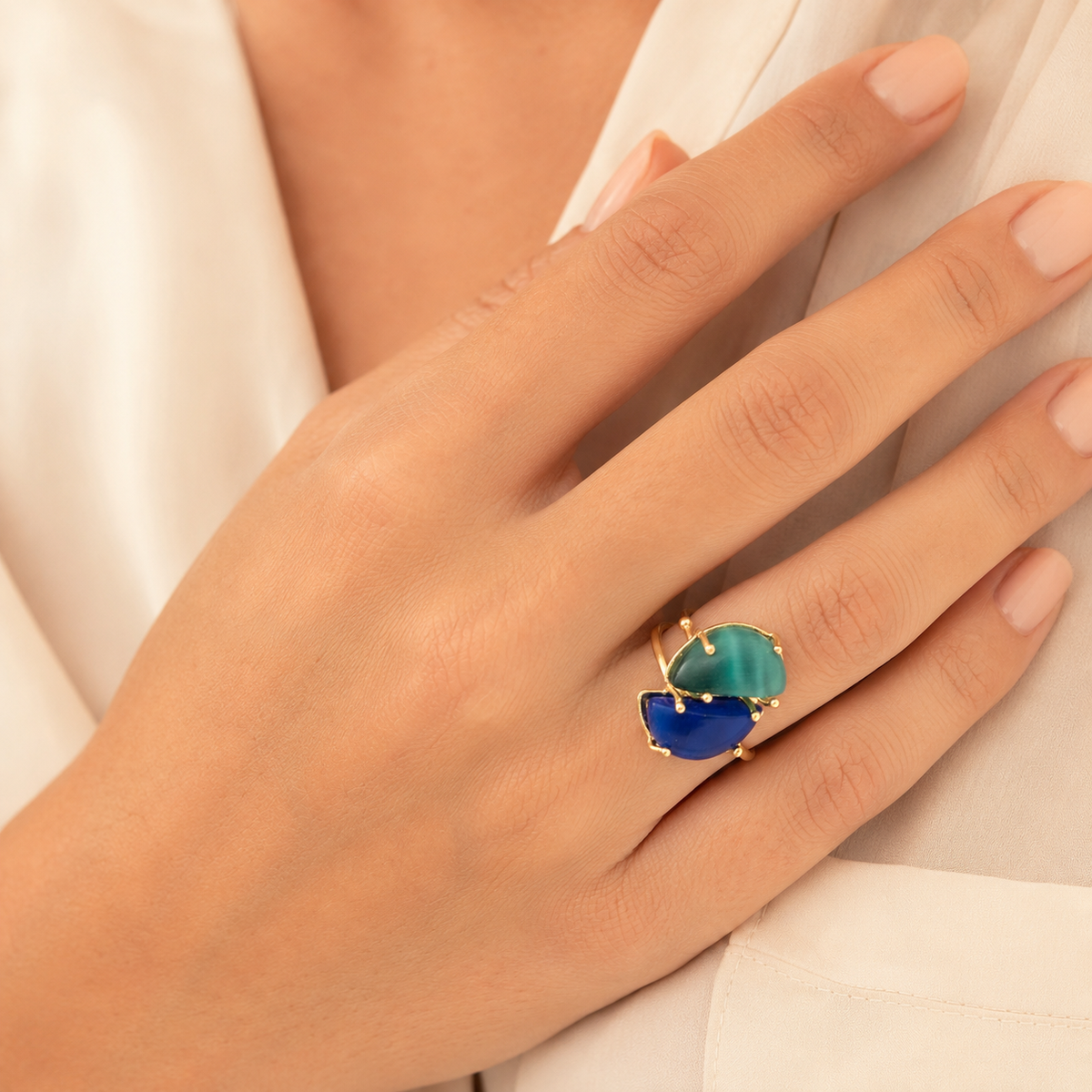 Gold-plated adjustable ring with two cat-eye style stones in blue and teal.