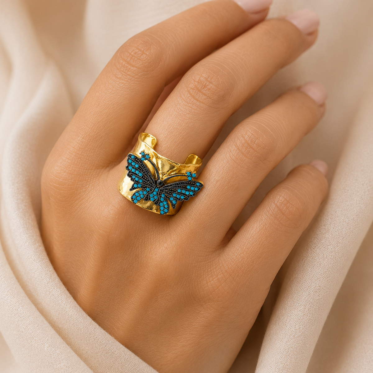 Gold-plated wide cuff ring with a turquoise blue butterfly design.