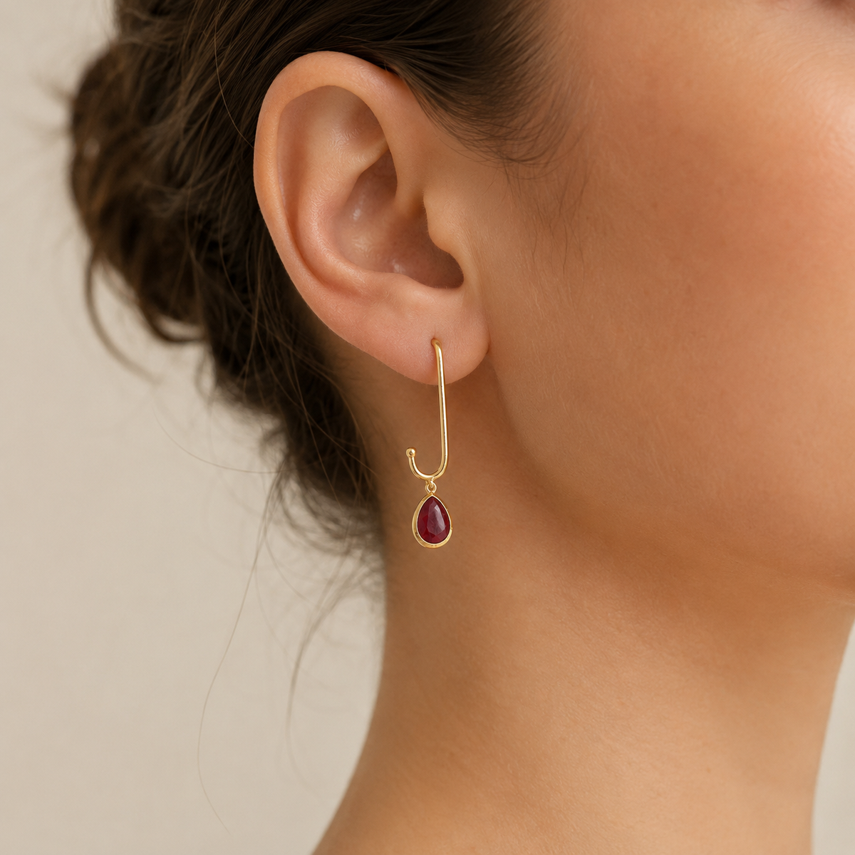 Gold-plated open paperclip drop earrings with green stone pendants.