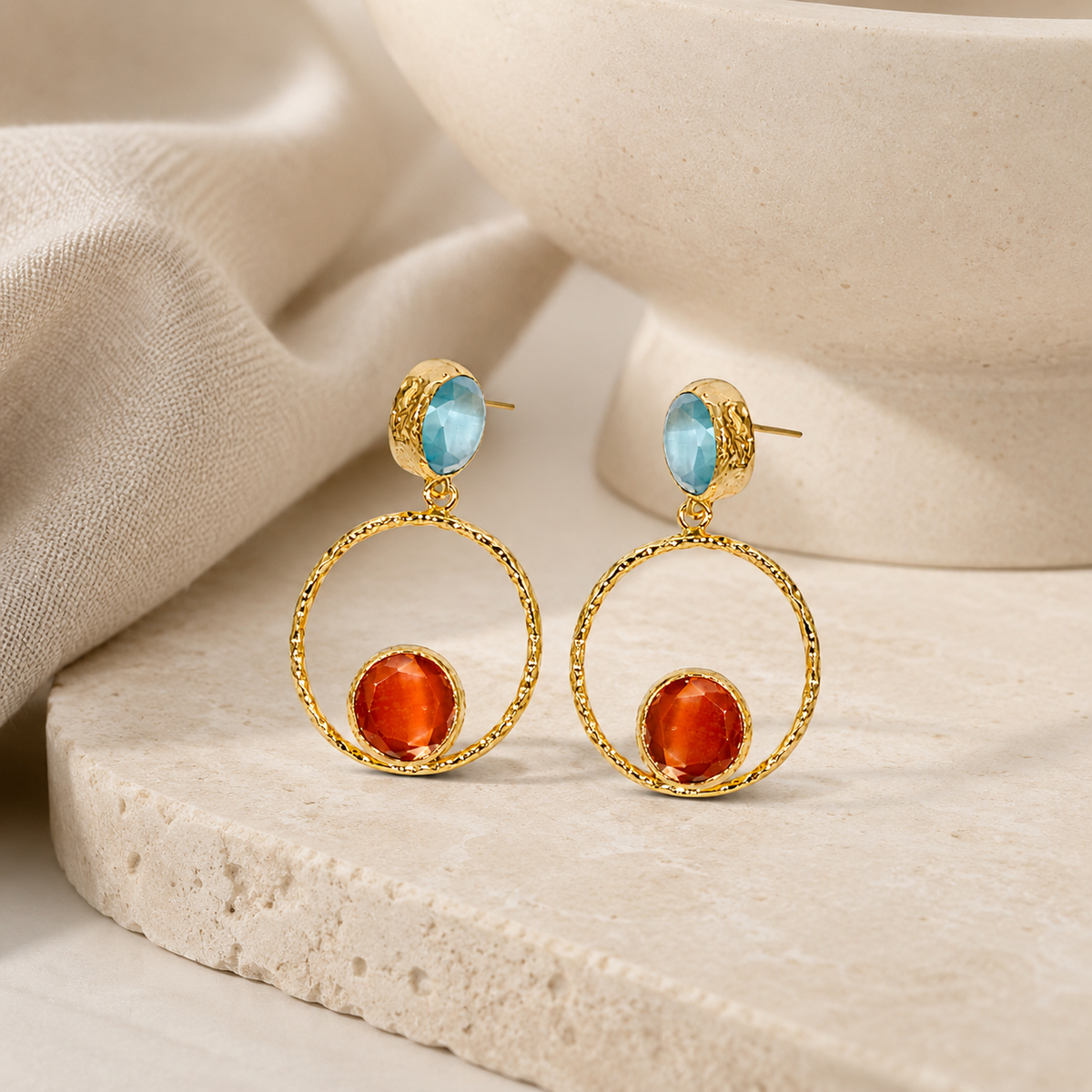Gold-plated drop earrings with a circular hoop silhouette and colorful stone-like accents.