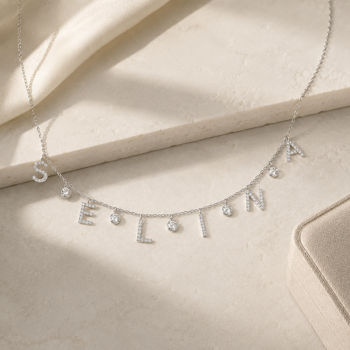 A personalized drop letter necklace with a silver-tone finish and shimmering accents.