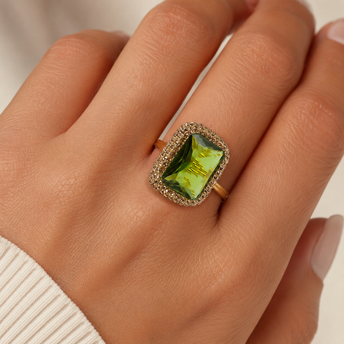 A close view of the octagon green stone ring in a gold-tone setting.