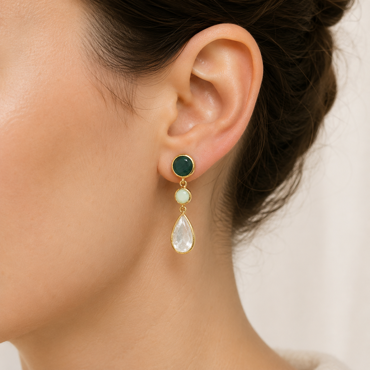Gold-plated drop earrings with layered green and clear stones.