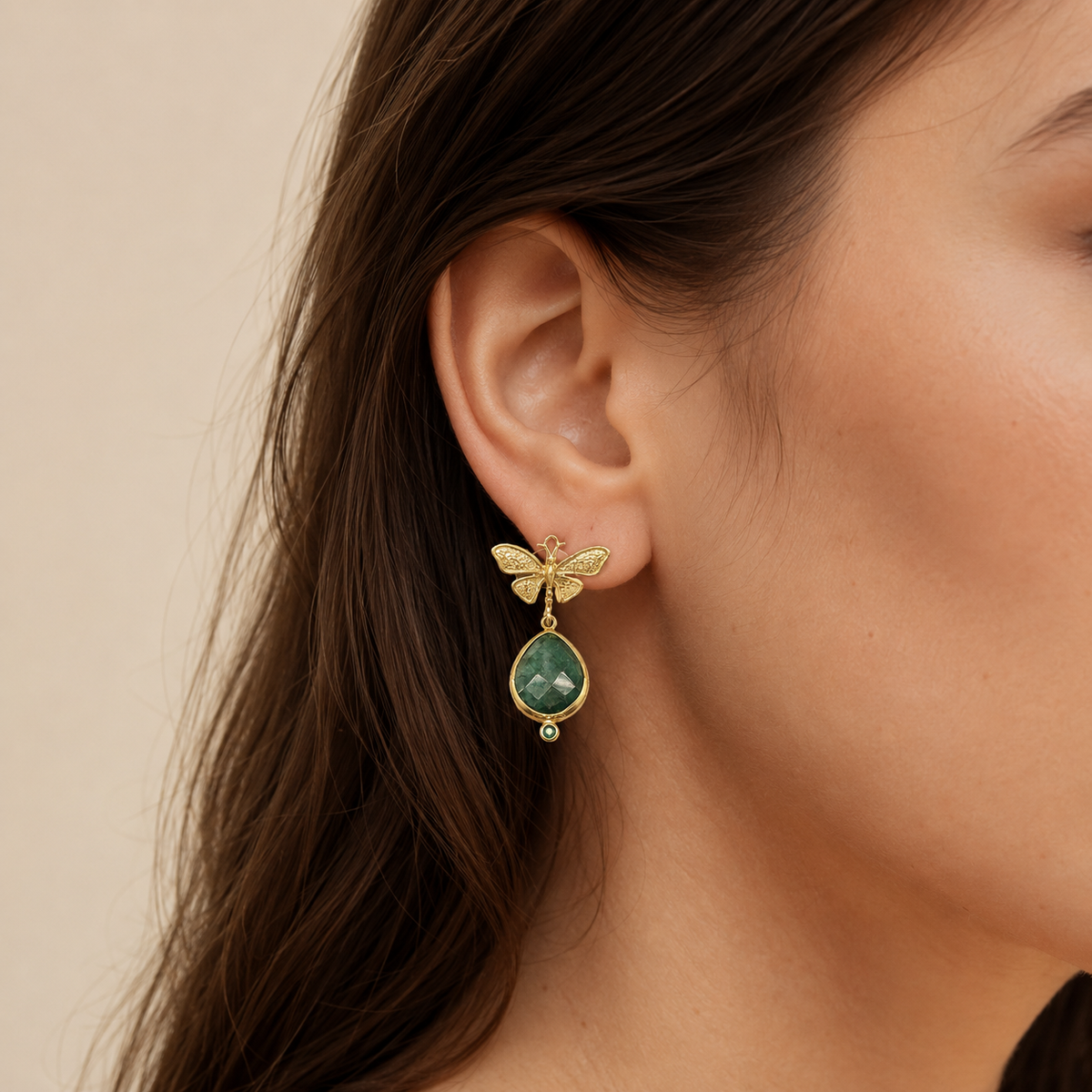 Gold-plated butterfly drop earrings shown front view with green teardrop stones.