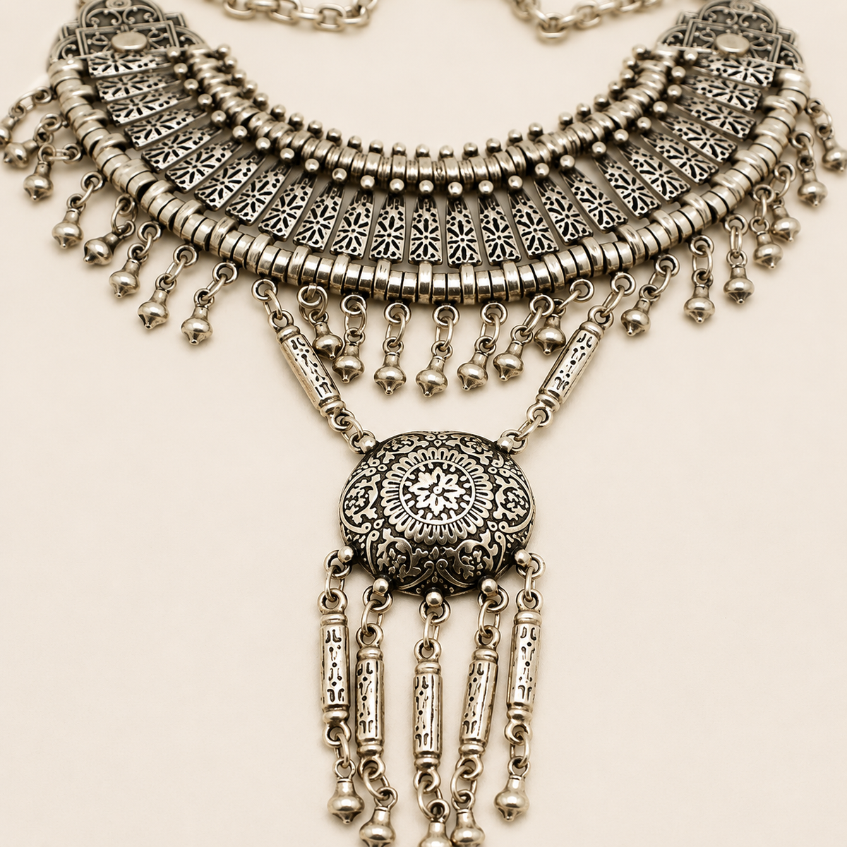 Close view of the silver-tone cutout fan texture and round pendant.