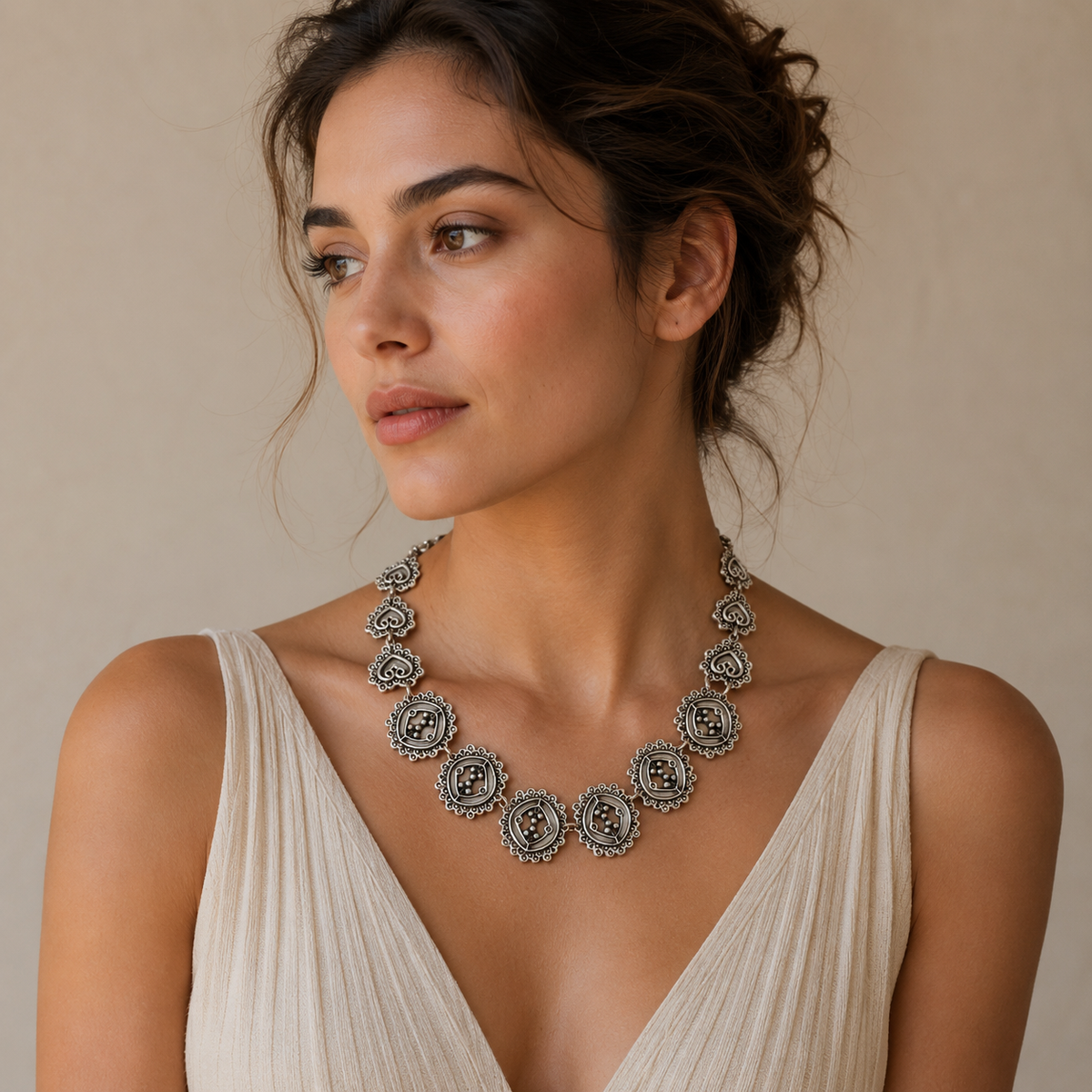 Silver-tone necklace with repeating circle links and textured accents.