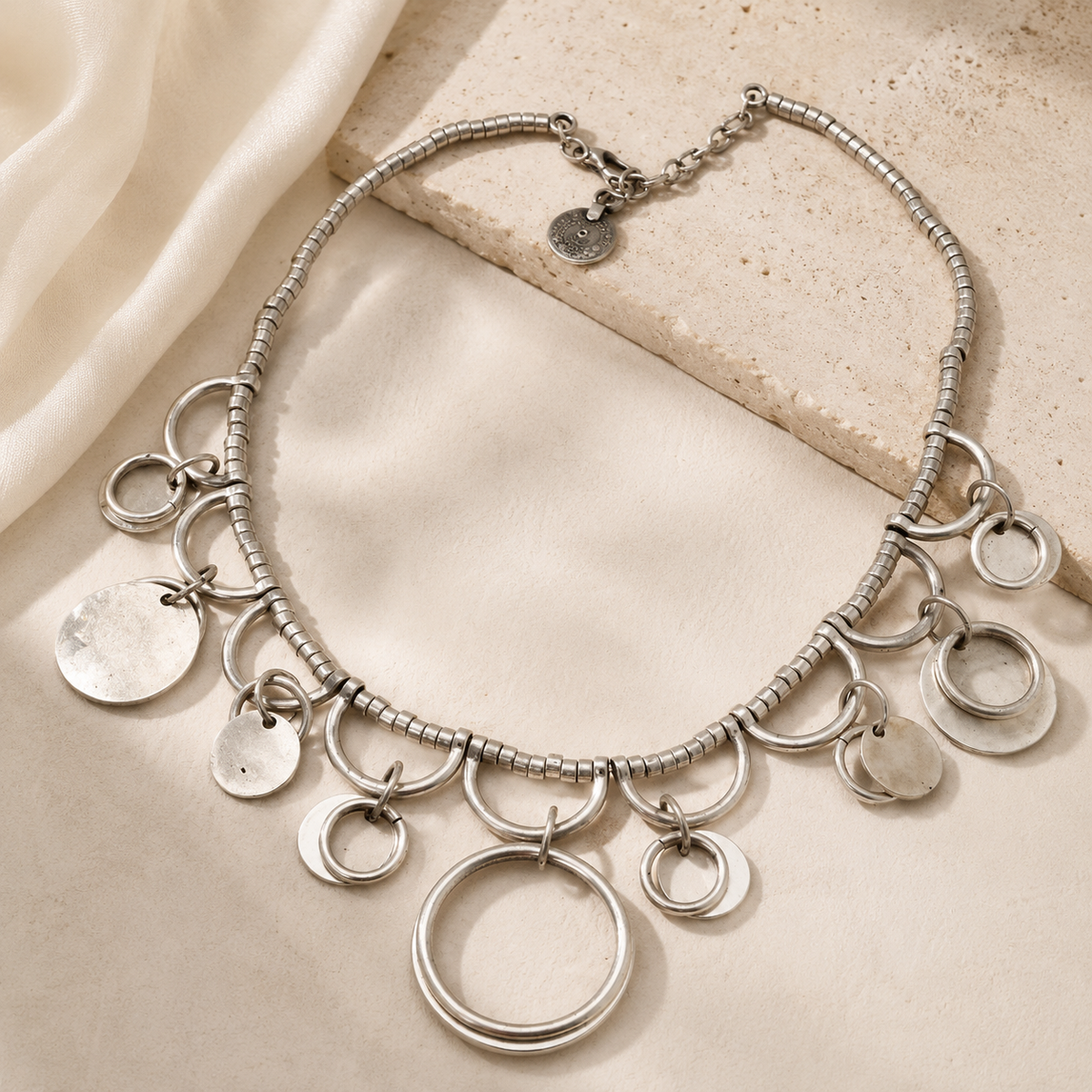 Silver-tone necklace with a modern charm silhouette.