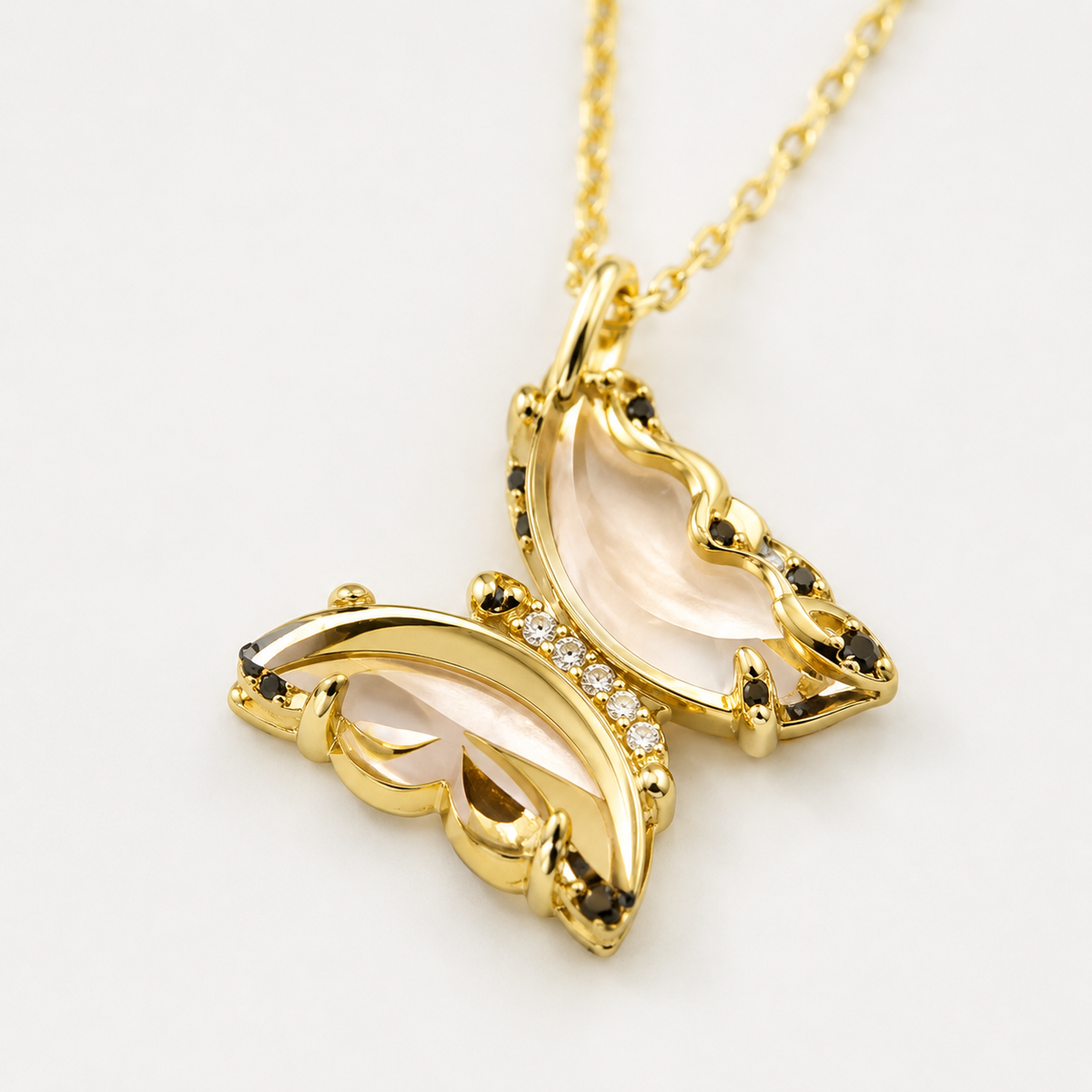 Close view of the butterfly pendant with pink glass and gold-tone detail.