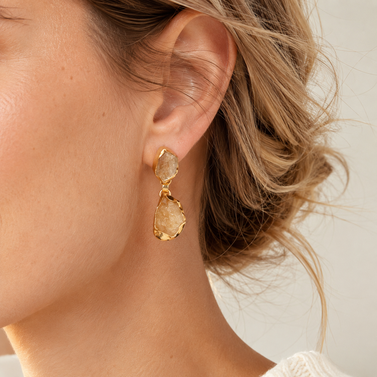 Gold-plated drop earrings with rough citrine-like stones shown in a close-up view.
