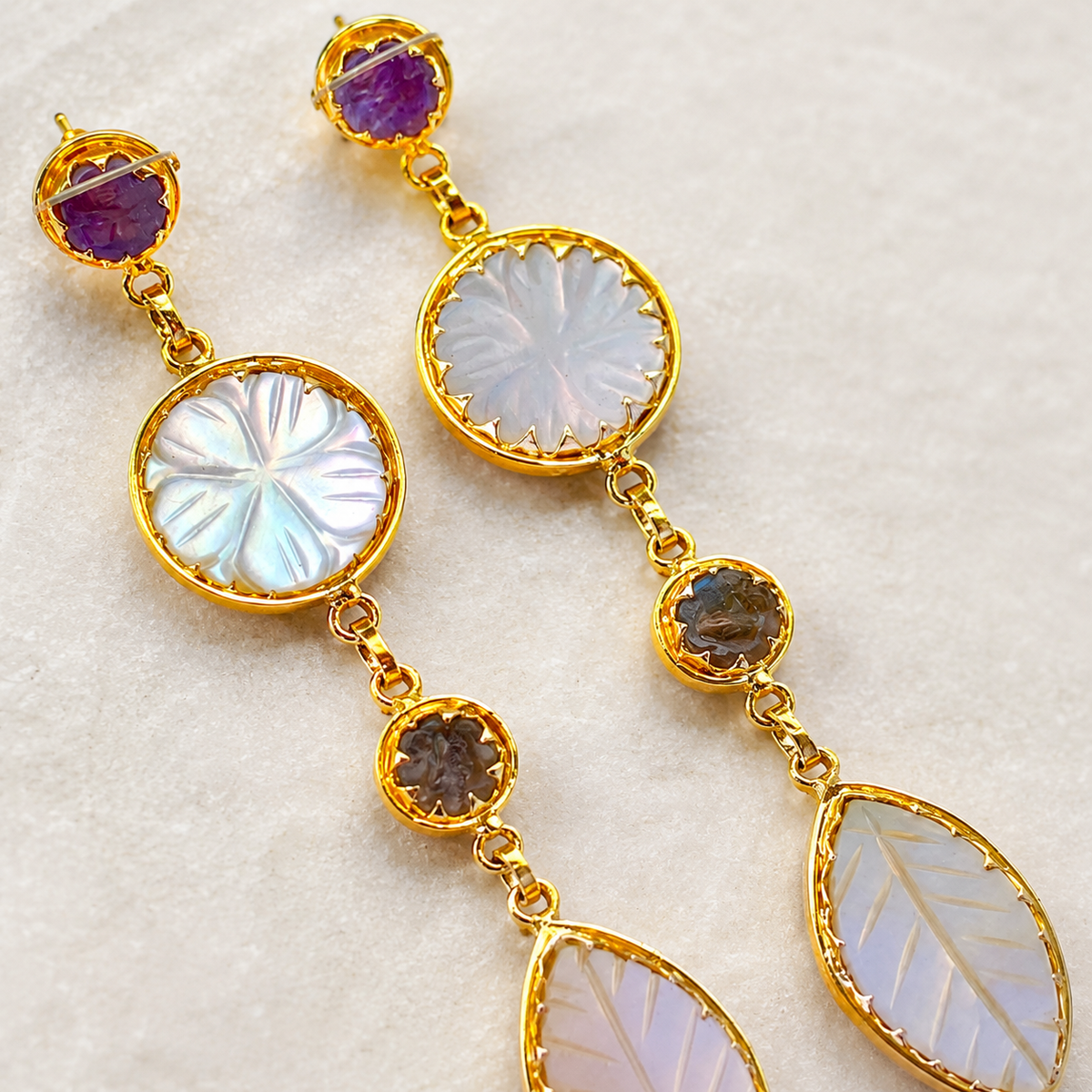 Close view of the gold-plated setting and stone details on the drop earrings.