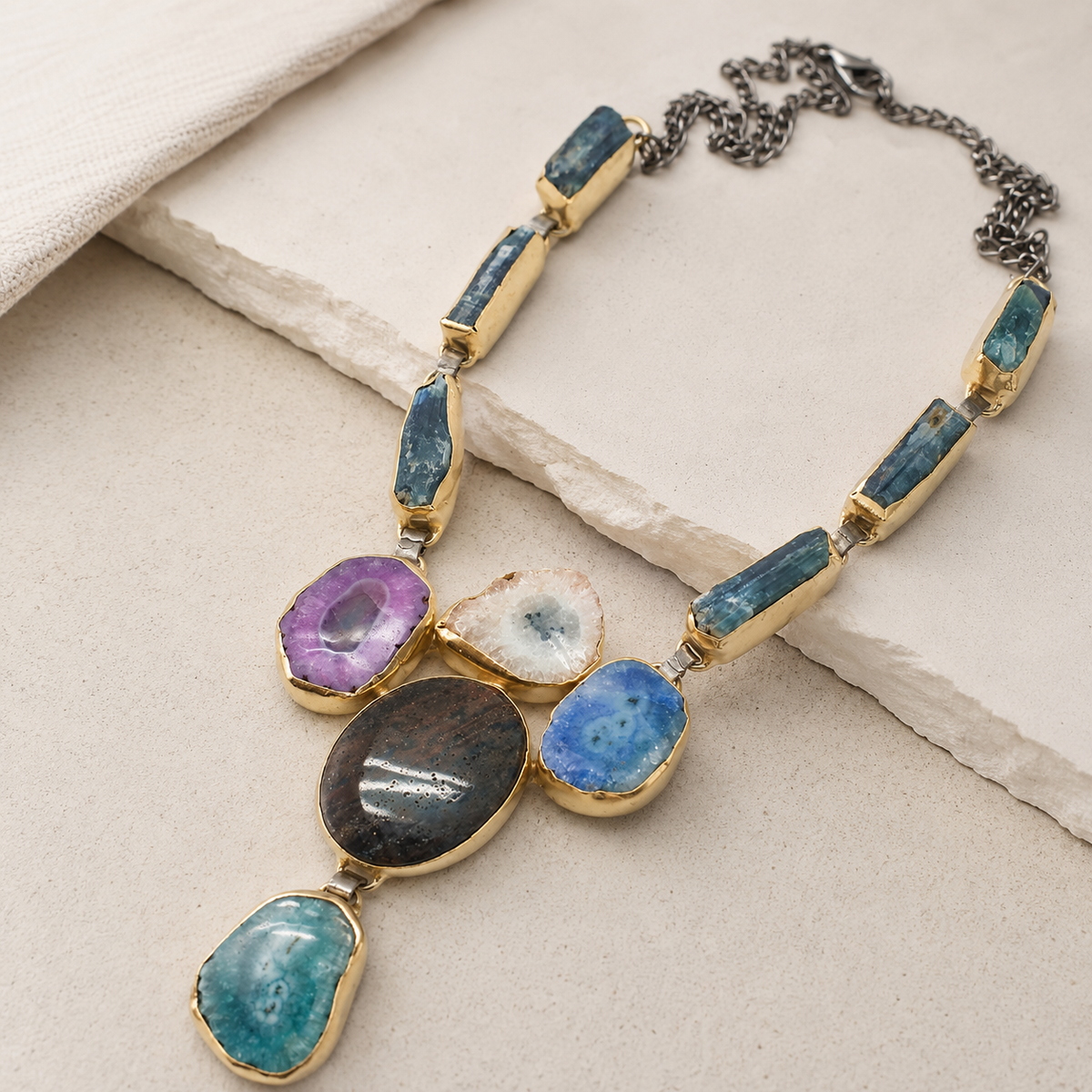 Angled view of a multi stone agate necklace with rectangular stone links and a gold-tone finish.