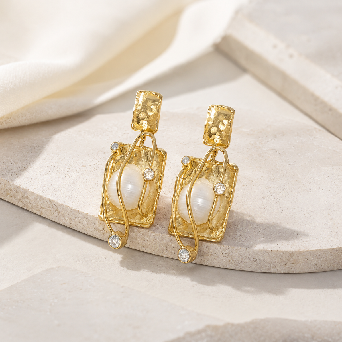 Gold-plated earrings with pearl center and clear accent stones.