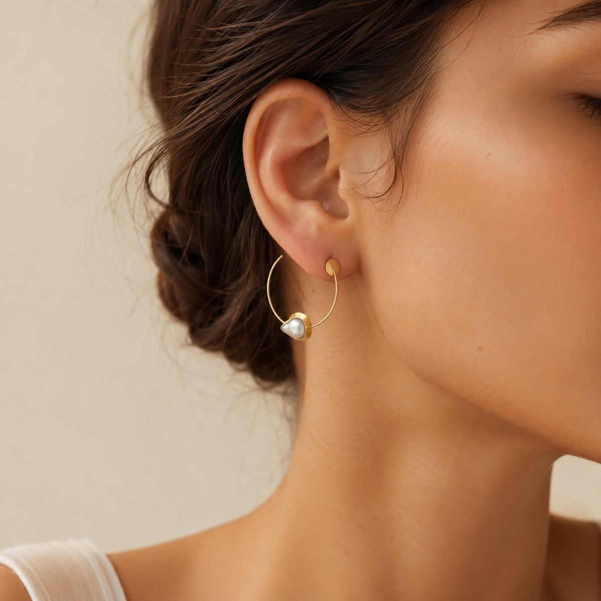 Gold-plated teardrop earrings shown from the front.