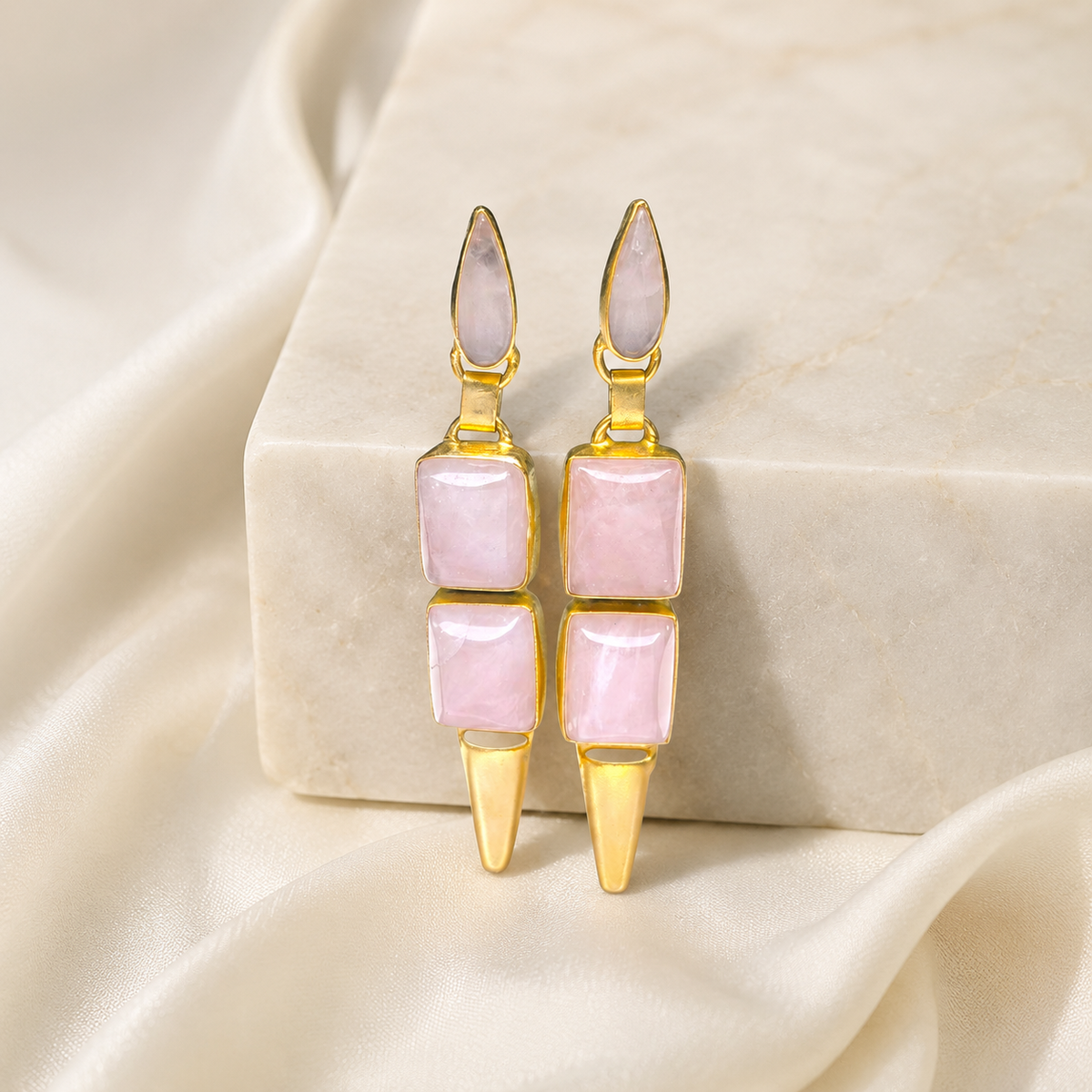 Pink geometric drop earrings with gold-plated details shown front view.