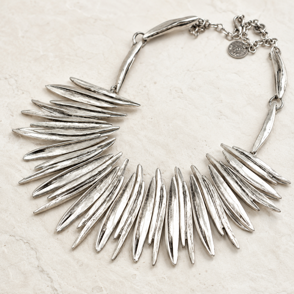Close view of the silver-tone spike details and chain clasp.