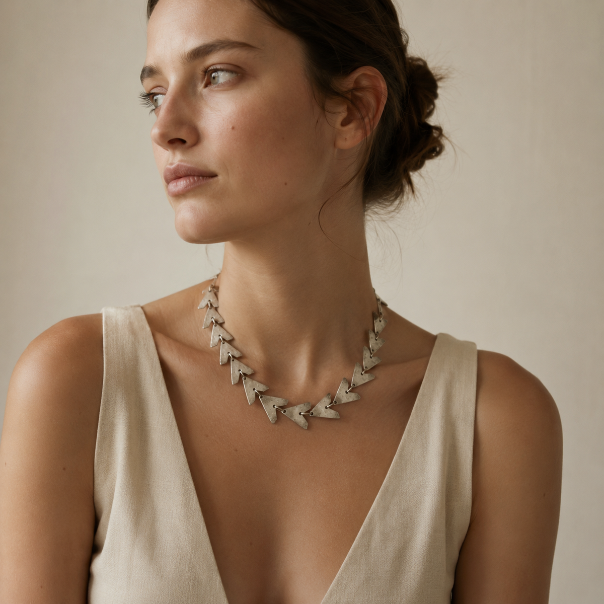Triangle link statement necklace with linked geometric shapes.