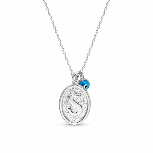 Silver-tone initial pendant necklace with a blue charm and textured oval design.