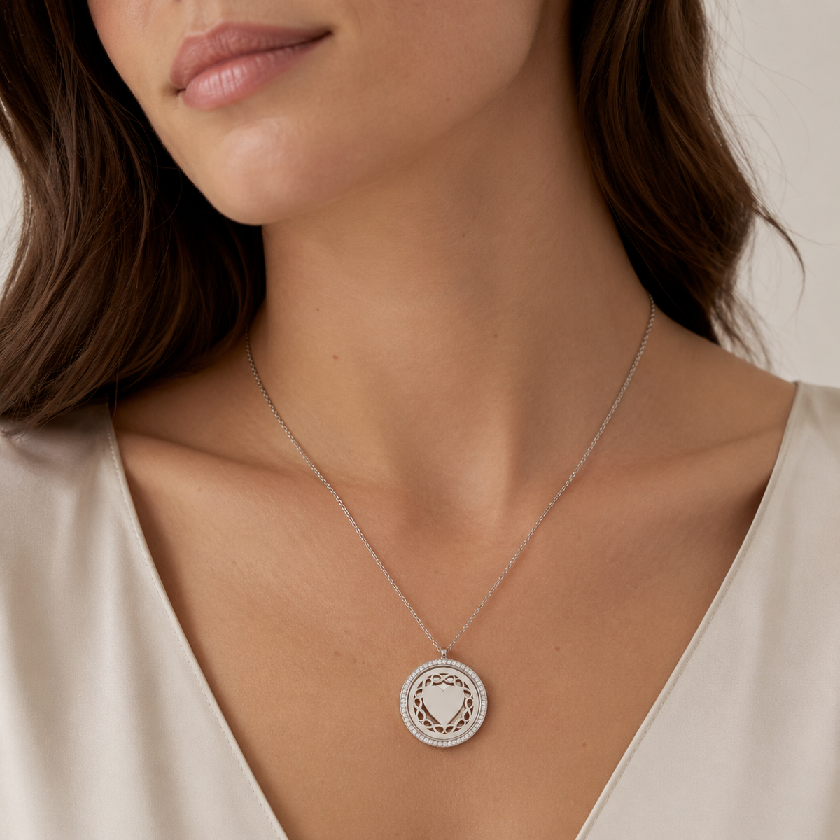 Round silver-tone pendant necklace with a delicate chain and sparkling border.