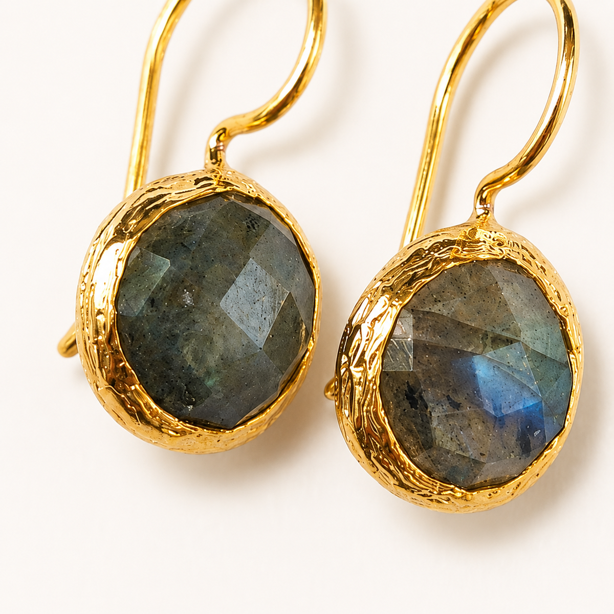 Close view of faceted labradorite set in a gold-plated frame.