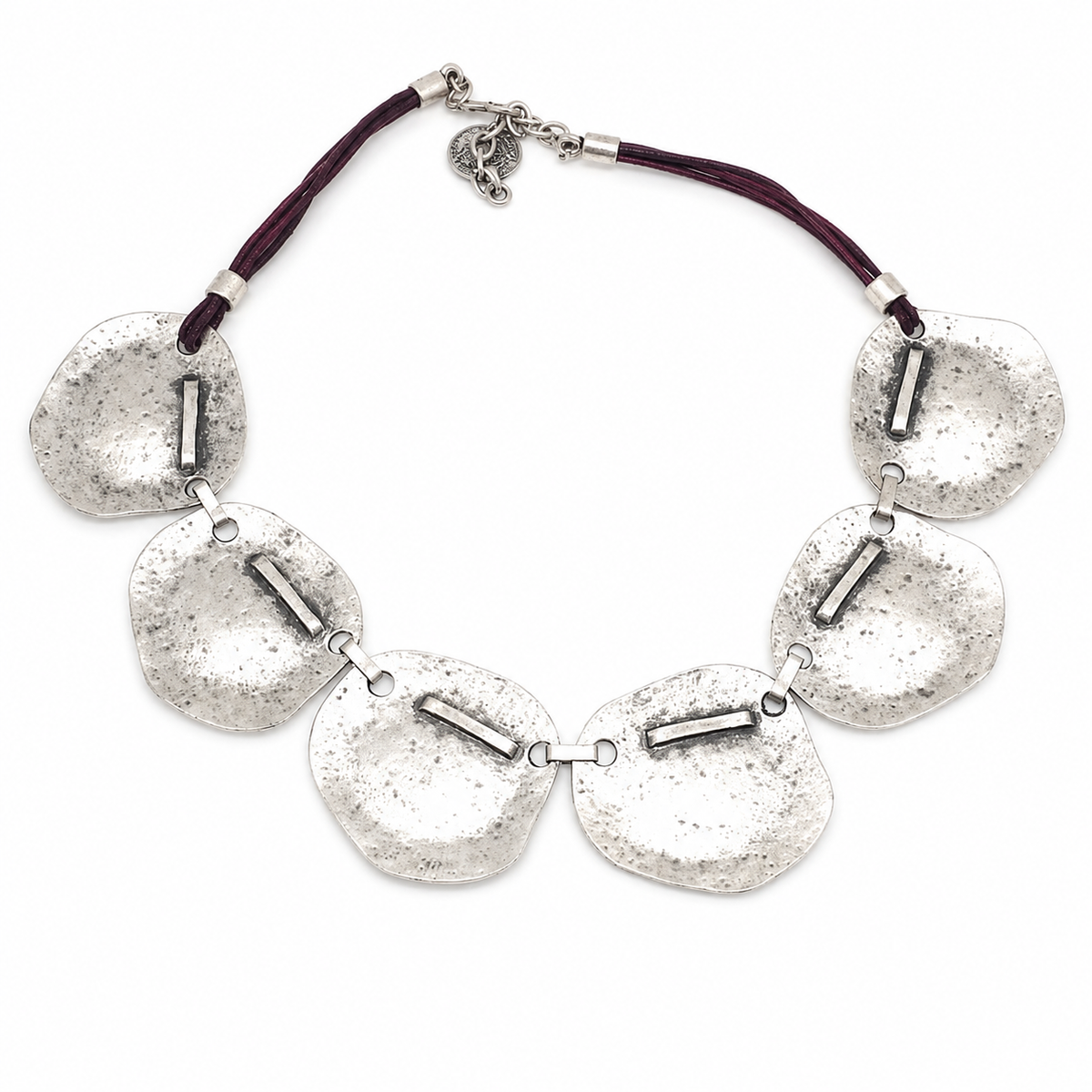 Hammered silver plate necklace with a sculptural linked design and dark cord detail.