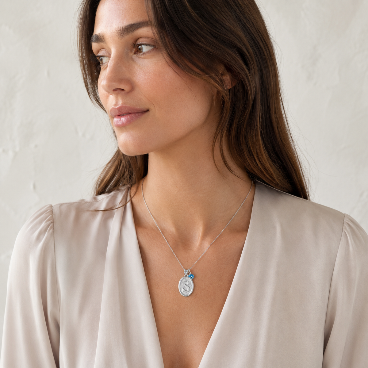 Silver-tone personalized initial necklace with a textured oval pendant and delicate chain.