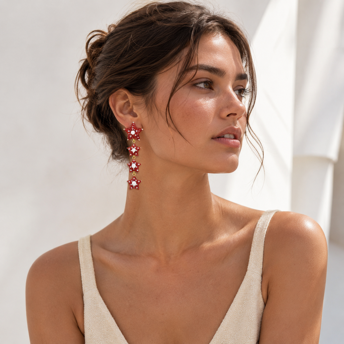 Red star earrings with pearl-like centers and CZ accents in a bold dangle style.